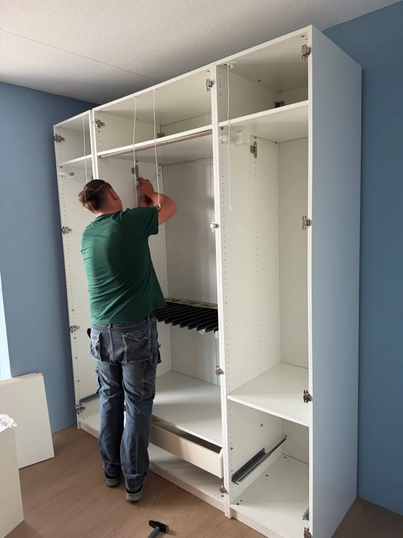 Een medewerker monteert een kast